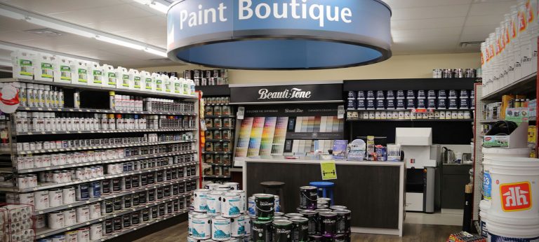 Photo of the paint center with stacks of paint cans, a wall of colourful paint chips, and a shelf of painting products