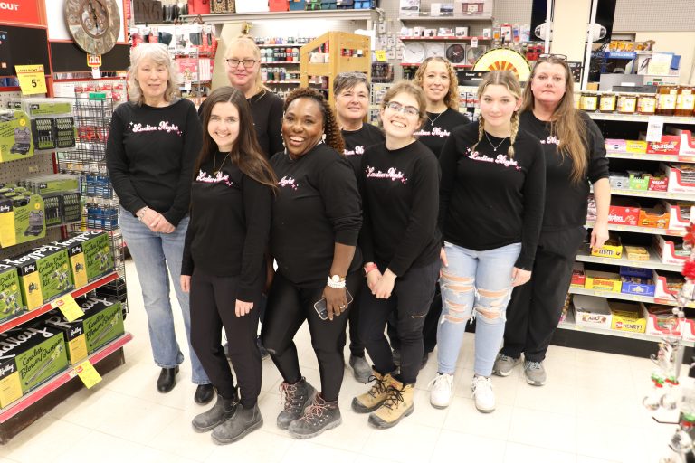 Nine women in a store aisle.