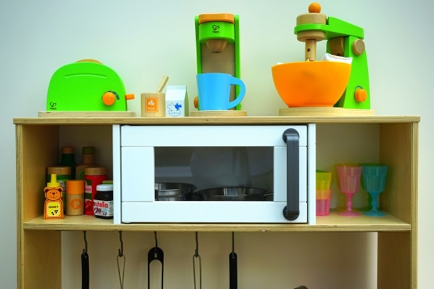 A microwave oven on a child’s play kitchen set.